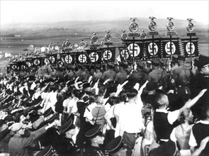 Hitler youth salutes the swastika during harvest celebration