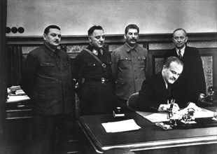 Molotov signant le traité d'assistance mutuelle entre l'U.R.S.S. et la République démocratique finnoise