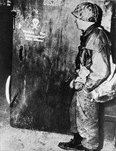 Soldat américain devant une chambre à gaz