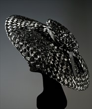 Large flat hat with flattened black cellophane crown