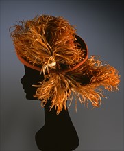 Rust coloured felt hat with dyed ostrich feather