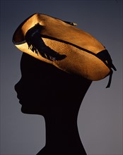 Chapeau de paille oriental décoré d'une bordure en ruban et de plume d'aigle