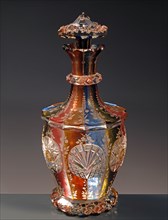 Bottle of Rosolio in Bohemian crystal of different colours, engraved with floral motifs.