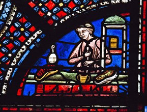 Un apothicaire prépare une potion dans un mortier (vitrail de Chartres)