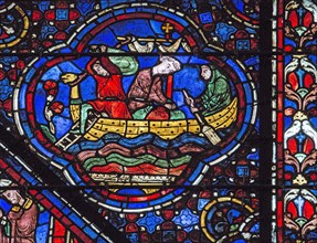 Des hommes déchargent des sacs de blé d'un navire (vitrail de Chartres)