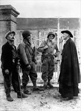 Deux soldats américains discutent avec un curé français à Nucilly en Normandie 1944.