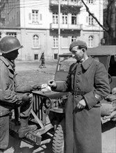 An American corporal gives a cigarette to a liberated French prisoner in Heidelberg (April 11,1945)