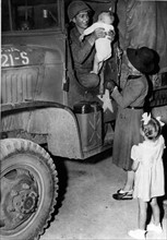 Un bambin reçoit un calin d'un libérateur américain de Patay (France), été 1944.