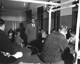 Le noir américain Paul Robeson chante pour un groupe de soldats américains à l'hôpital de Garches (France). 7 août 1945