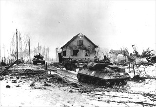 Des chars d'assaut français traversent la ville de Bettenhoffen ravagée par la guerre (France, janvier 1945).