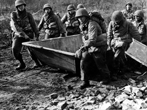 Des ingénieurs de combat américains tirent leur péniche d'assaut sur la berge du fleuve Roer (Allemagne) 23 février 1945