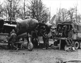 L'équipe de maintenance de la 9e U.S Air Force effectue la révision d'un chasseur-bombardier "P-38 Lighting" (Belgique, décembre 1944)