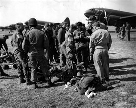 U.S paratroopers confer on field before taking off to jump east of the Rhine river (March 24, 1945)