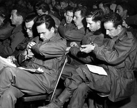 Les soldats du groupe US de transport des troupes synchronisent leur montre. (24 mars 1945)