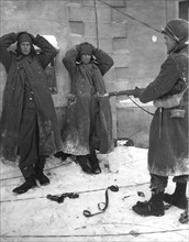 Un soldat américain tient deux SS Allemands capturés à Sart (Belgique). 9 janvier 1945