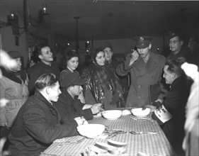 Un général américain goûte la soupe servie au centre israélite de Landsberg en Allemagne. 6 décembre 1945