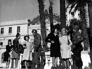 Jeunes femmes de Monaco et membres de la police militaire américaine à Monaco. 24 janvier 1945