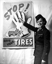 A W.A.C admires a tire conservation poster in his office in Marseille (France) March 27, 1945