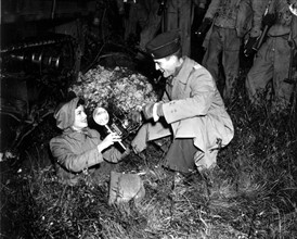 A U.S. Major hands a camera to INS War Correspondent (England, 1943)
