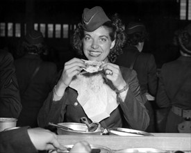 Caporal du corps d'armée féminin U.S. savourant son premier repas au Havre.
(22 juillet 1945)