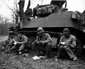 Soldats américains lisant leur courrier près de Schwanheim, en Allemagne.
(Mars 1945)
