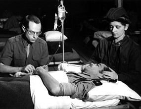 Un ancien prisonnier de guerre américain reçoit une transfusion de sang dans une antenne chirurgicale en Normandie.
(5 mai 1945)