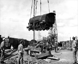 The first locomotive is unloaded from a libery ship at Bremenhaven (Germany) July 18,1945