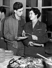 Un soldat américain et une femme du corps d'armée féminin U.S., lors d'un dîner organisé pour Thanksgiving, à Paris.
(23 novembre 1944)