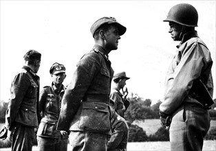 Le Lt. General Omar N. Bradley en conversation avec un prisonnier de guerre allemand.
(Août 1944)