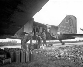 Jerricans of gasoline is being loaded into a C-47 (Orléans-France), March 30,1945
