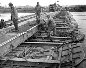 Le génie américain répare un pont provisoire sur la Roer, en Allemagne.
(25 février 1945)