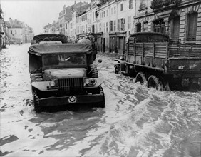 Motorized units of U.S.  Army negociate flooded French streets in Rambervilliers, Autumn 1944