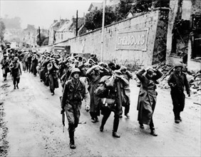 Germans prisoners march through streets of Cherbourg, June 27, 1944.