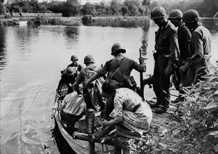 Des civils français font traverser la Mayenne à des troupes américaines. 
(Août 1944)