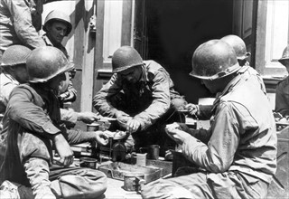 Repas de troupes américaines dans une rue de Cherbourg, 27 juillet 1944