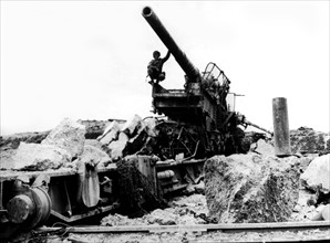 Soldat américain examinant un canon géant allemand en Normandie, juin 1944