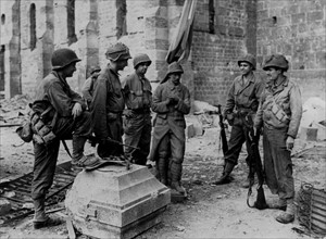 Soldats américains autour de la base d'un monument commémorant les soldats de la Première guerre mondiale (été 1944).