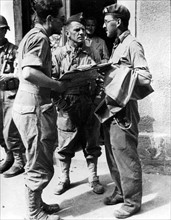 Two  French officers talk to a British officer in Ecouche, summer 1944