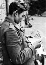 Soldat allemand lisant une annonce de capitulation en Normandie
(Eté 1944)