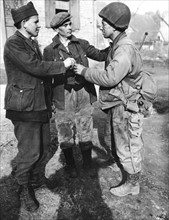 American soldier shares cigarets with Russian workers in France, March 18, 1945