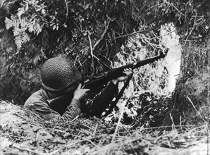 An American infantryman shoots at enemy on the Vire front, summer 1944