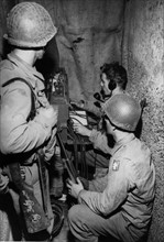 Soldats américains du Corps des transmissions installant des lignes de communication à Saint-Lô.
(Juillet 1944)
