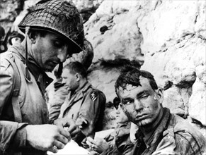 Un Américain reçoit les premiers soins en France.
(Juin 1944)
