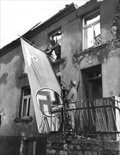 Le drapeau nazi est retiré d'un bâtiment à Saarlautnern, en Allemagne. (1945)