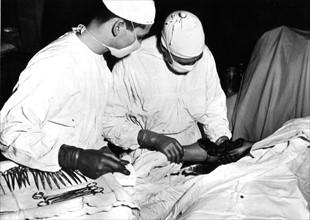 American surgical team inspects arm of wounded soldier in France (1945)
