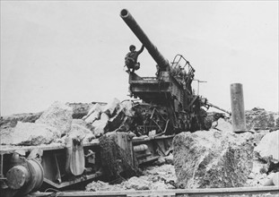 Soldat américain examine un canon allemand (juin 1944)