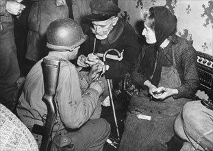 Soldat américain réconfortant des civils français (juin 1944)
