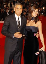 US actor George Clooney (L) and Italian actress Elisabetta Canalis (R) arrive for the premiere of