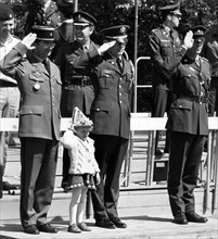 Small child with officers during the military parade at the 'Armed Forces Day' in Berlin