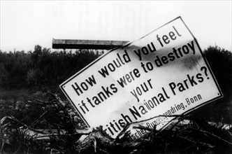 Damaged sign against the devastation of nature by British troops
